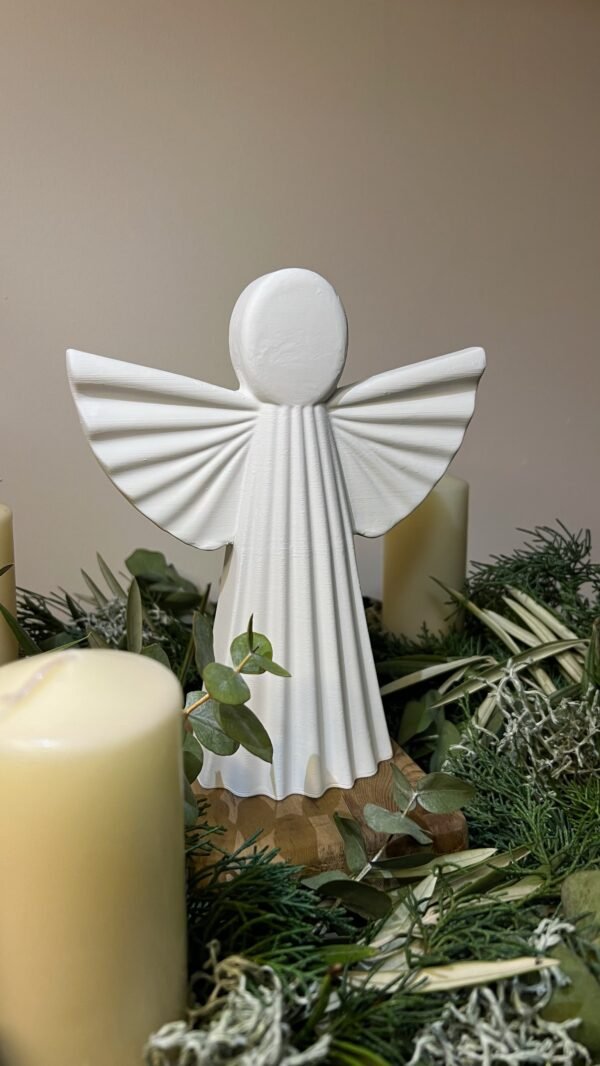 Ángel de la Guarda blanco entre velas y ramas de Navidad, foto real