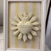 Cuadro del Sagrado Corazón de Jesús en relieve con tela rayas amarillas apoyado de pie sobre un mueble