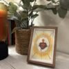 Detente del Sagrado Corazón de Jesús con marco madera con interior claro junto a la entrada de casa