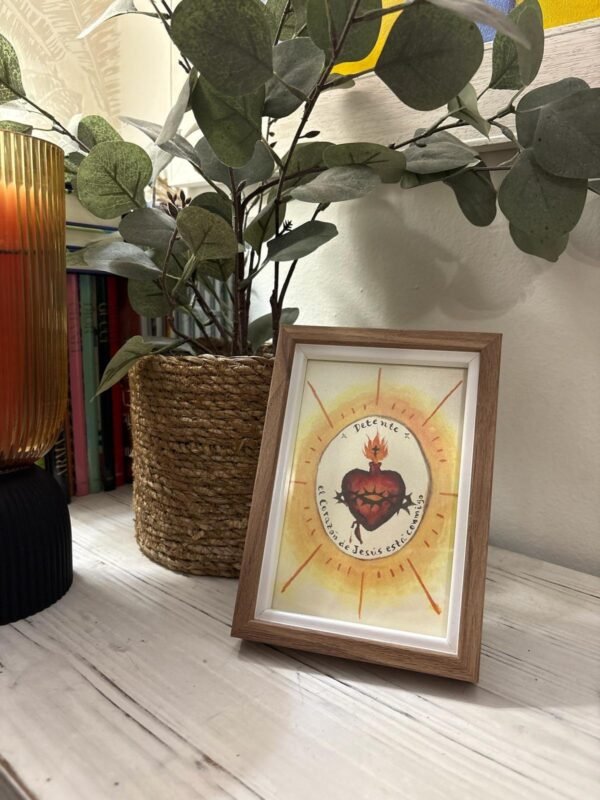 Detente del Sagrado Corazón de Jesús con marco madera con interior claro junto a la entrada de casa