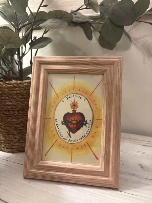 Detente del Sagrado Corazón de Jesús con marco madera sobre el mueble del recibidor
