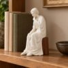 Figura de San José en una estantería junto a libros