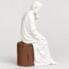 Figura de San José de perfil, sentado sobre el tocón en tono madera