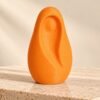 Virgen de dedo – Naranja Virgen de dedo de color naranja de pie sobre piedra, con la figura de María en hueco